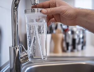 Plumber Replacing A Water Filter Under A Sink. Featuring Water Filtration And Plumbing Maintenance